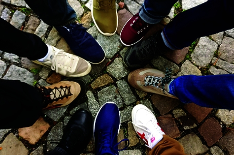 a group of 10 people each standing with one foot in the centre. The picture is taken from above.