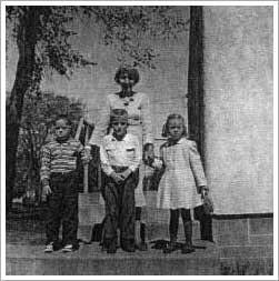 An old black and white photo with a woman and 3 children